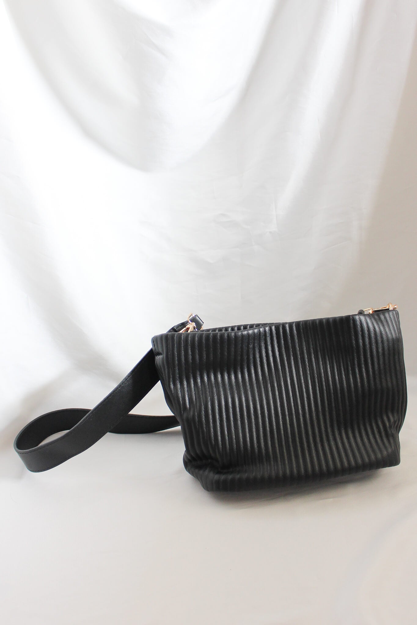 A small ribbed detail bag with multiple ways for carry. Transformable into a crossbody bag. Trapezium style mini bag