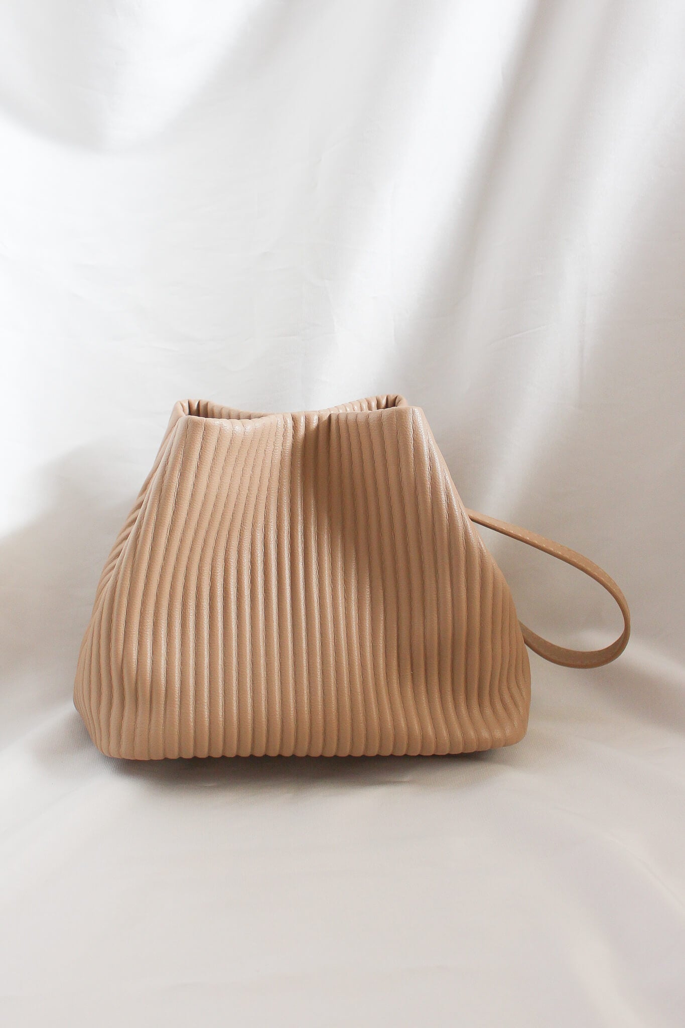 A small ribbed detail bag with multiple ways for carry. Transformable into a crossbody bag. Trapezium style mini bag