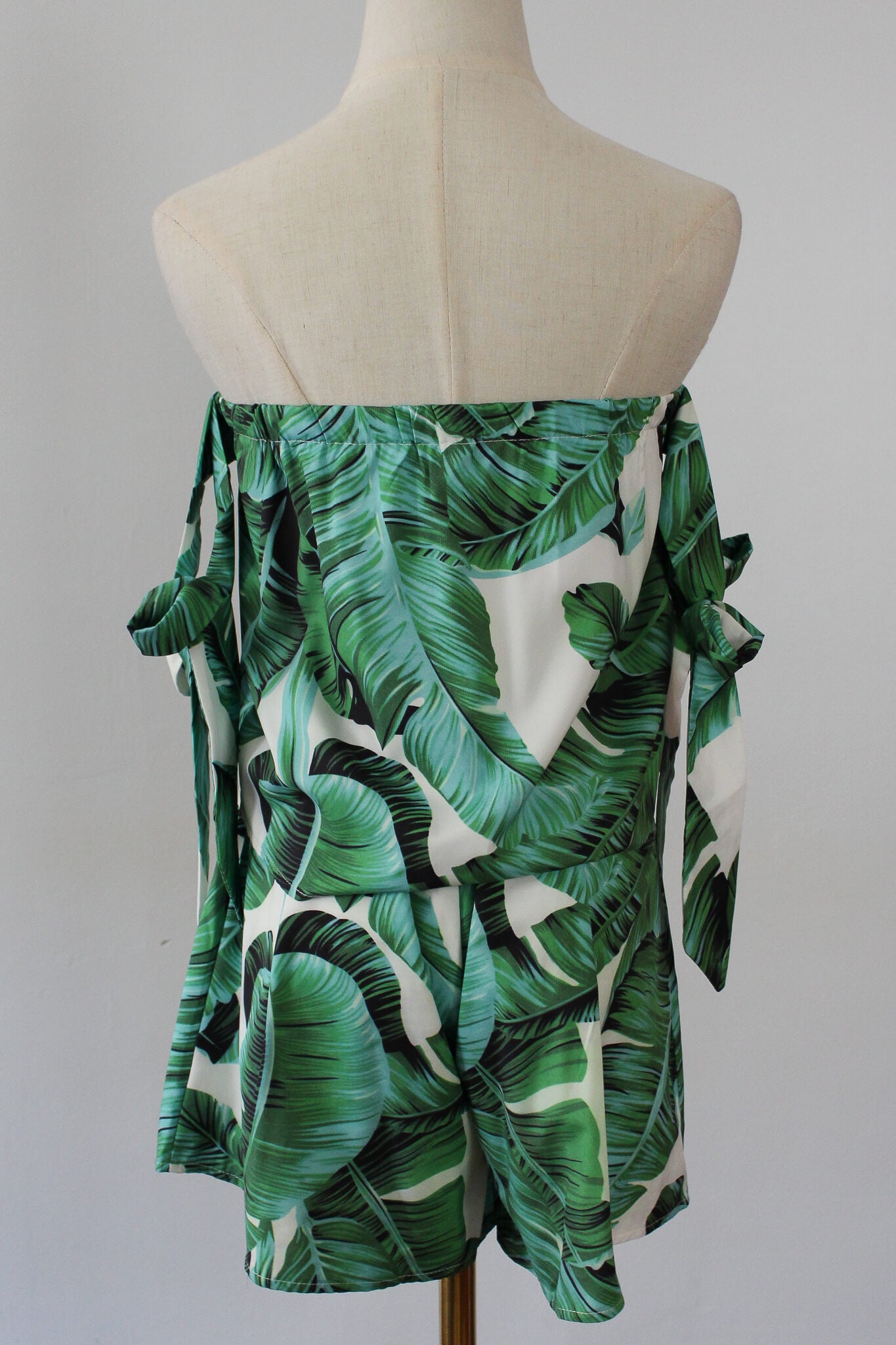 Two set piece containing strapless tube top with  tied ribbon sleeve and shorts. Leaf prints 