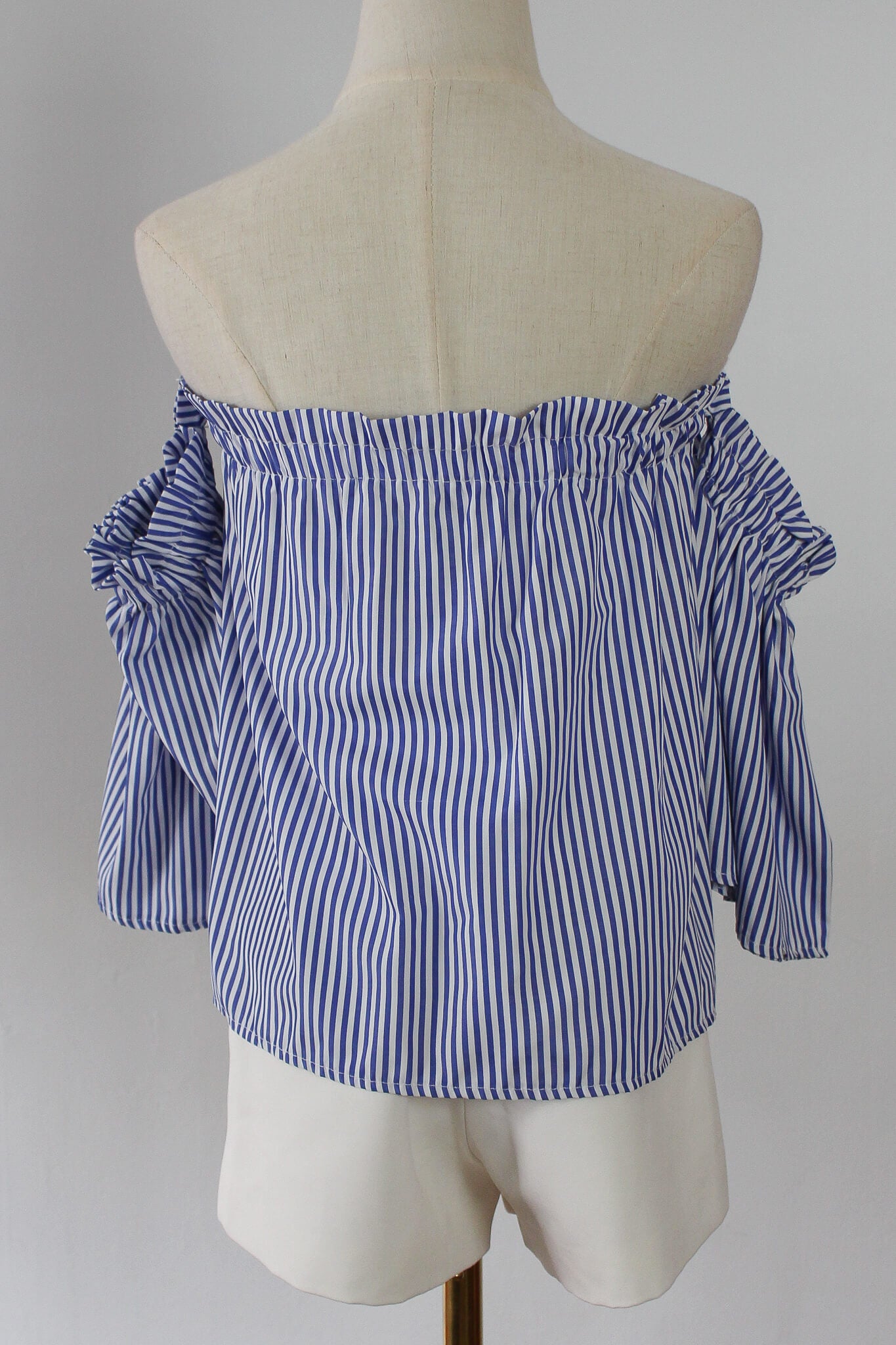 A blue and white striped off-shoulder top, perfect for the summer beach with nautical vibes. 
