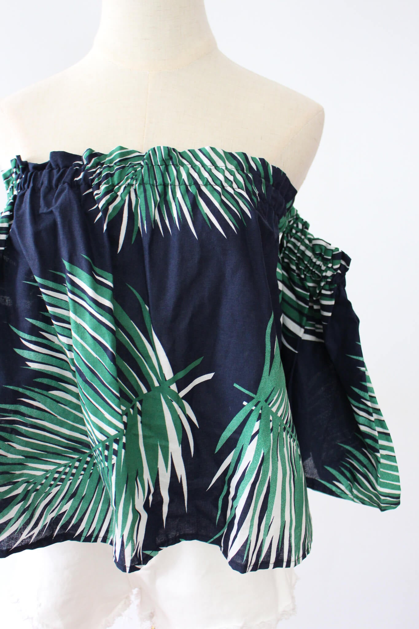 Navy blue off-shoulder top with palm leaf print, perfect for summer